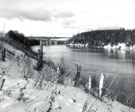 grayscale photograph: a snowbanked river