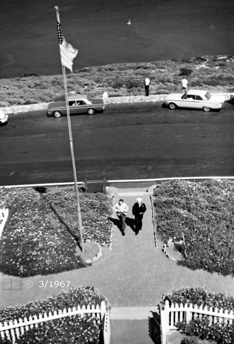 B/W photo: View of tourists approaching lighthouse entrance; taken from atop lighthouse - Embedded text: 3/1967