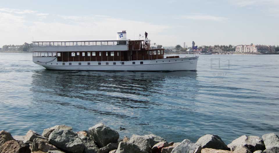 View of antique yacht with Coronado apartment blocks in backgrond