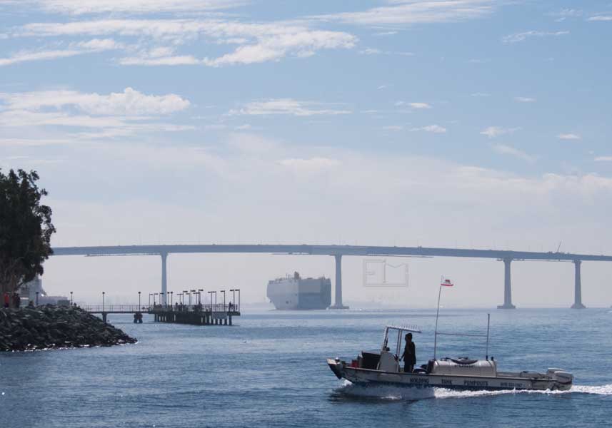 Utility moter boatat marina enterance with Coronado Bridge in background