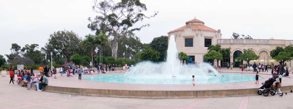 Wide view of people around large, main fountain with Science Center in background
