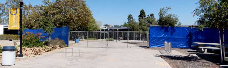 View of fence surounding old bookstore/cafateria buildings, from ground level