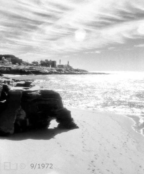 Infrared b/w photo - Portrait view of rock formation and beach - Embedded text: 9/1972