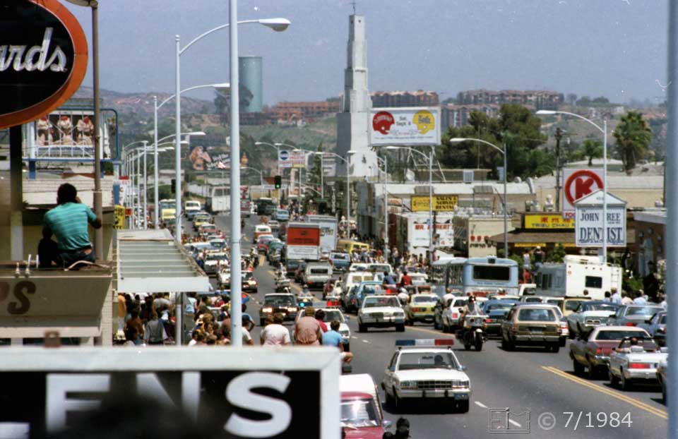 Color photo: Telephoto view of oncoming motercade - Embedded text: 7/1984