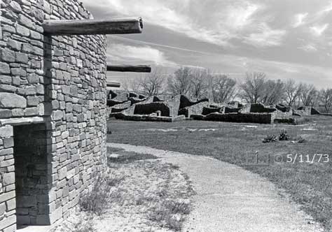 B/W photo: View of ruins/central plaza while walking adjacent to Great Kiva - Embedded text: 5/11/73