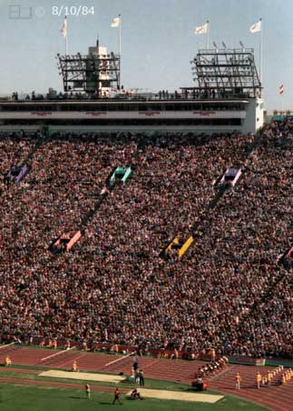 Color photo: Start of a hurdles race with full stadium seating and grandstand in background - Embedded text: 8/10/84