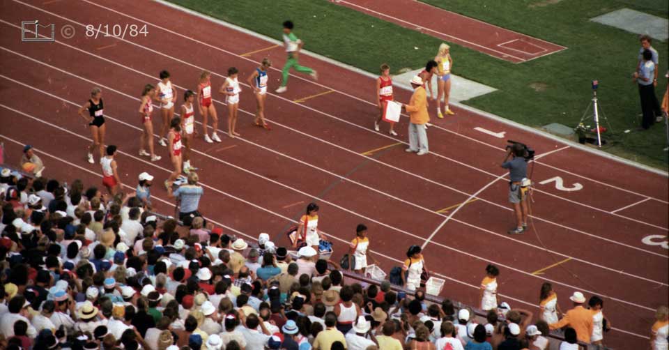 Color photo: Women prepare to start 3000 meter race - Embedded text: 8/10/84