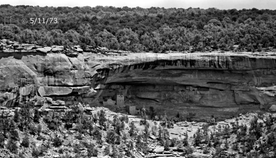 B/W photo: Medium view of cliff dwellings and the mesa above - Embedded text: 5/11/73
