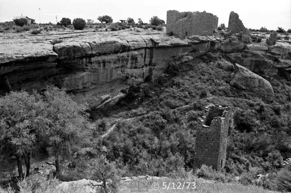 B/W photo: Square tower ruin in canyon and  ruins on masa beyond - Embedded text: 5/12/73