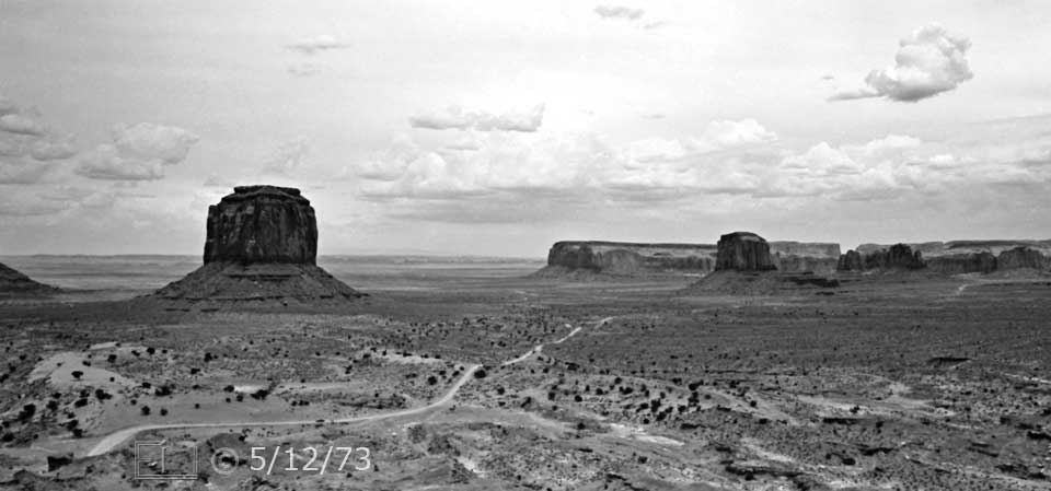 B/W photo: Roadway in foreground leading to butte and mesas in distance - Embedded text: 5/12/73
