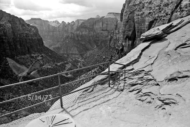 B/W photo: Wide angle view of spectator area to overlook canyon, cliffs and switch backed roadway - Embedded text: 5/14/73