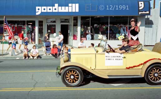 Color photo: Miss Clairemont waves to spectators from a small ~1930s convertible automobile - Embedded text: 12/1991