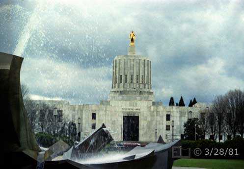 Color photo: Close partial view of water fountain with Capital building as backdrop - Embedded text: 3/28/81