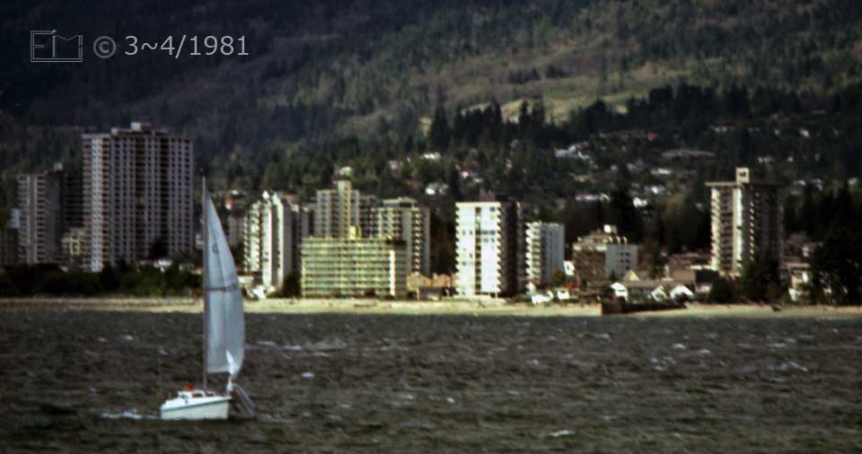 Color photo: Landscape, telephoto view of small sailboat and North Vancouver - Embedded text: 3~4/1981