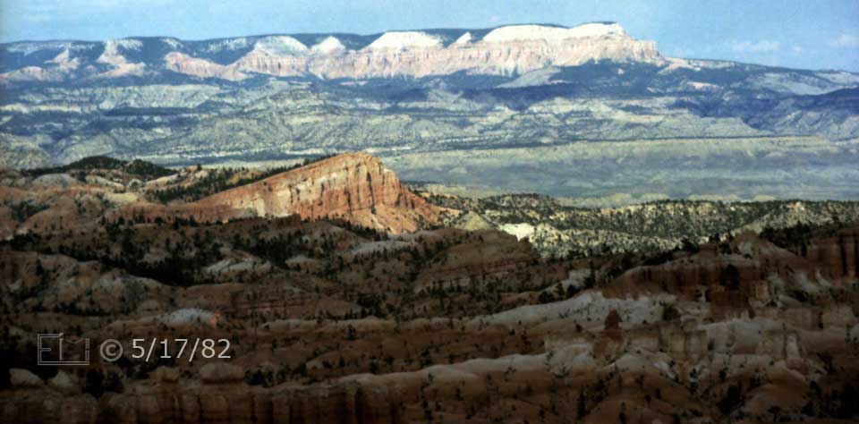 Color photo: Telephoto, low sun in sky view of Bryce Canyon landscape - Embedded text: 5/17/82