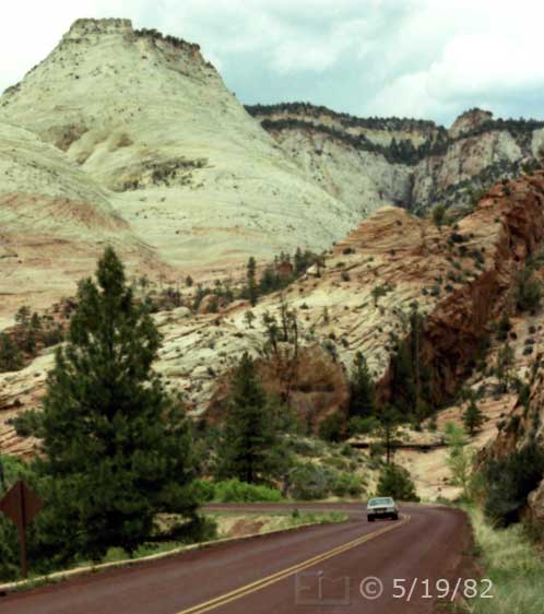 Color photo: Highway traffic dwarfed by monumental landscape - Embedded text: 5/19/82