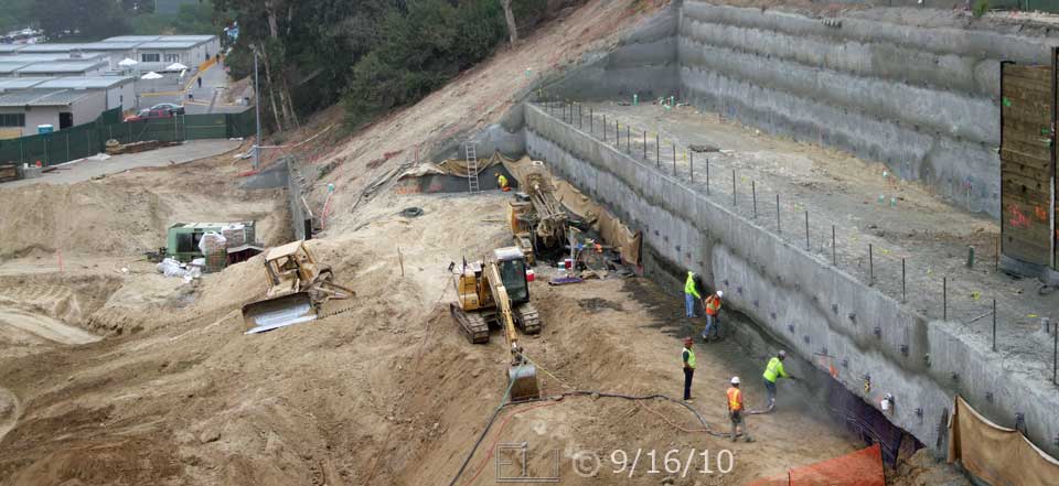 Color photo: Construction of large retaining wall continues; old retaining wall has been removed - Embedded text: 9/16/10