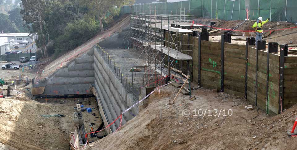 Color photo: Construction of large retaining wall nears completion - Embedded text: 10/13/10