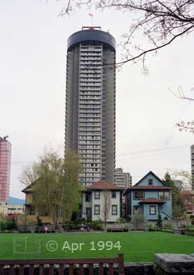 Color photo: Old wood-framed residences contrasted with modern high-rise apartment building - Image taken: 4/7~12/1994