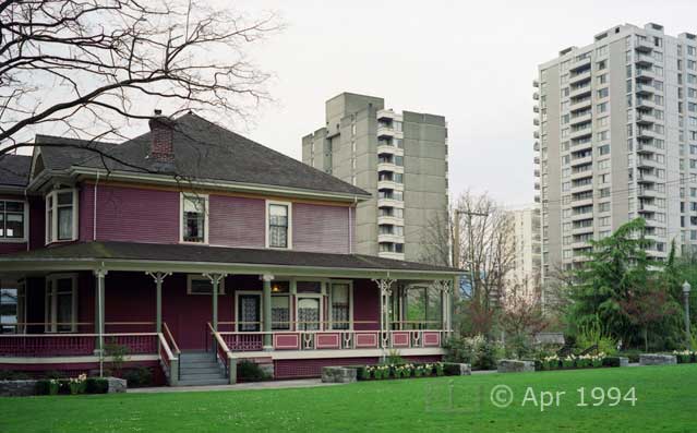 Color photo: Old wood-framed residence contrasted with modern high-rise apartment buildings - Image taken: 4/7~12/1994