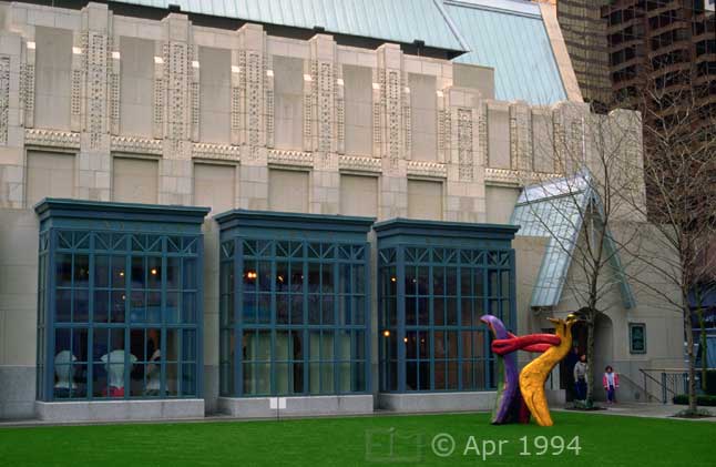 Color photo: Family exiting a building with modernistic sculpture on front lawn - Image taken: 4/7~12/1994