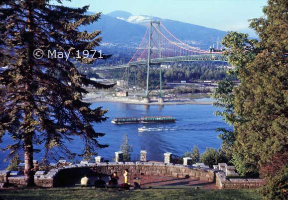 Color photo: View from Stanley Park of vessels passing underneath Lions Gate Bridge - Embedded text: May 1971